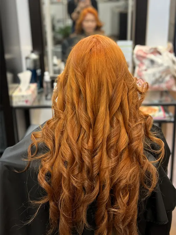 Vibrant copper-orange hair after a professional hair bleaching and colour service by CocoRez in Port Coquitlam.