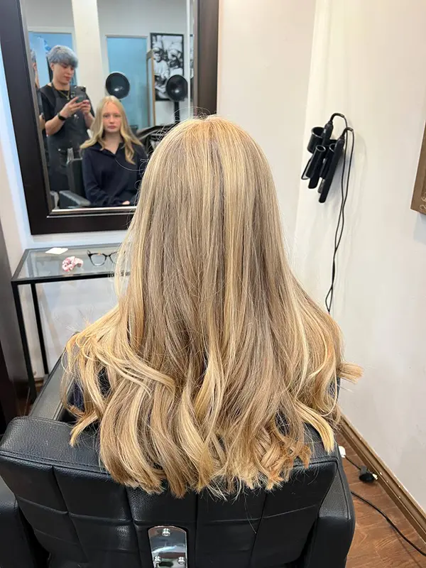 Blonde highlights adding dimension and brightness to long hair by CocoRez in Port Coquitlam.