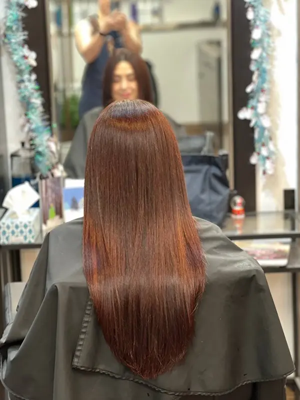 Glossy chestnut hair color with a sleek finish by CocoRez in Port Coquitlam.