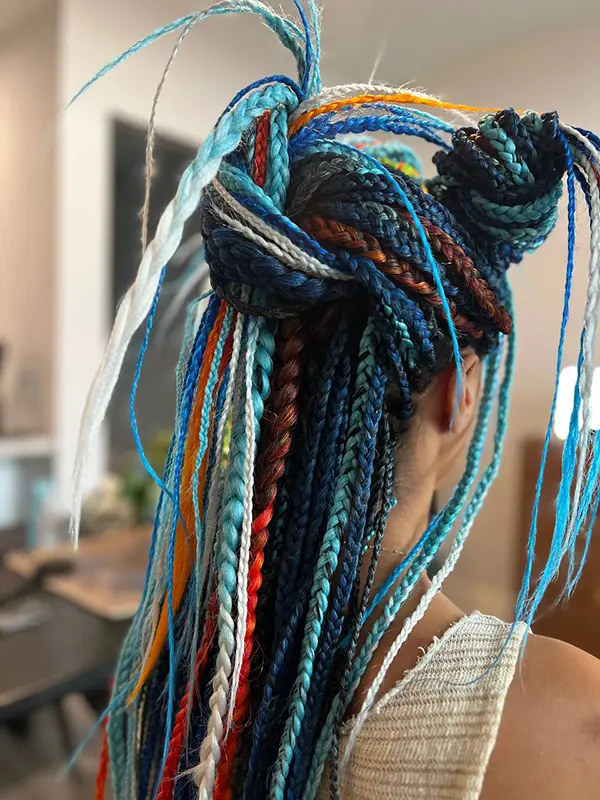 Colourful festival long box braids with vibrant blue, teal, orange, and white extensions by CocoRez in Port Coquitlam.