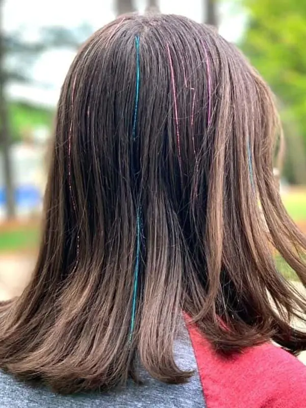 Subtle colourful hair tinsel professionally installed on natural hair at CocoRez in Port Coquitlam.