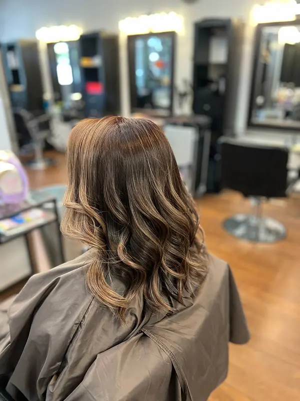 Brunette hair styled with soft waves after a professional shampoo and blow-dry service by CocoRez in Port Coquitlam.