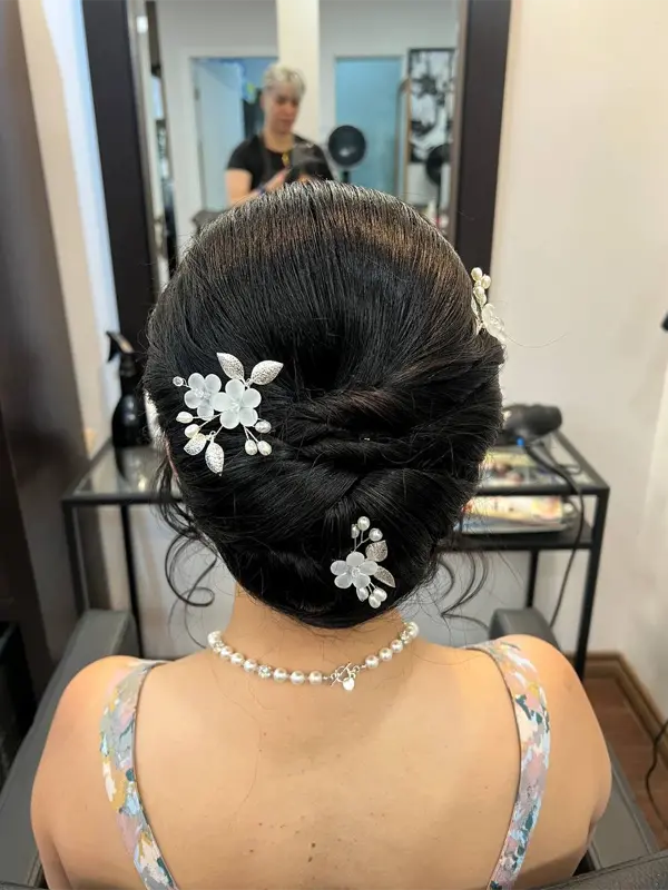 Classic bridal updo with elegant floral hair accessories by CocoRez in Port Coquitlam.