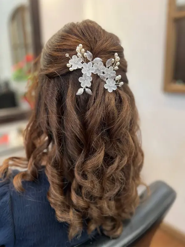 Romantic half-up hairstyle with soft curls and floral hair accessories by CocoRez in Port Coquitlam.