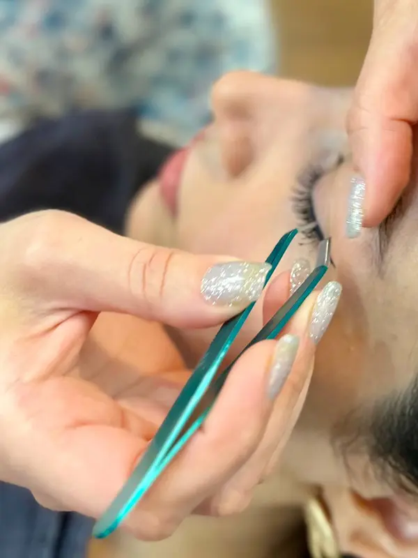 Precision eyebrow detailing with professional tweezers during an eyebrow service at CocoRez in Port Coquitlam.